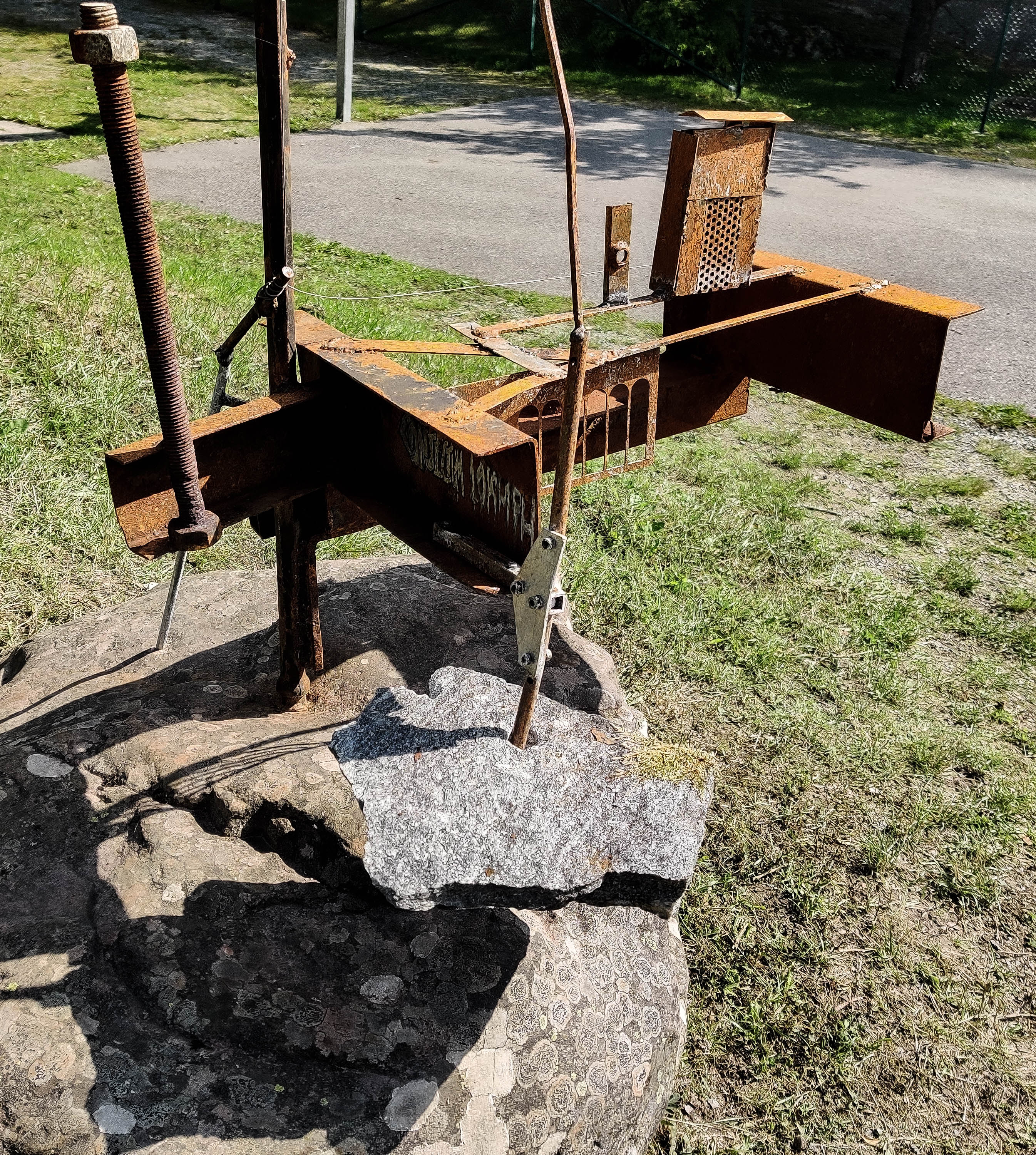 Rusty steel sculpture with I-beams on a boulder. Rostig stålskulptur med I-balkar placerad på ett stenblock.